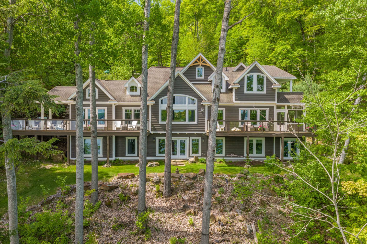 161 Town Line Road East: the residence viewed from the lake side, surrounded by mature trees