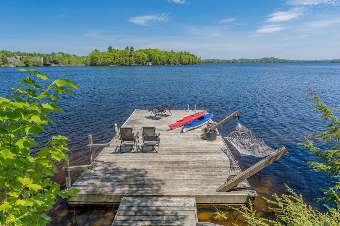 Private dock on Fairy Lake with chairs, kayaks, and hammock
